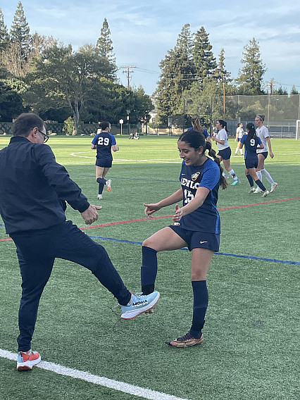 Knights coach Ross Ireland congratulates sophomore Krista Arreola after her assist.