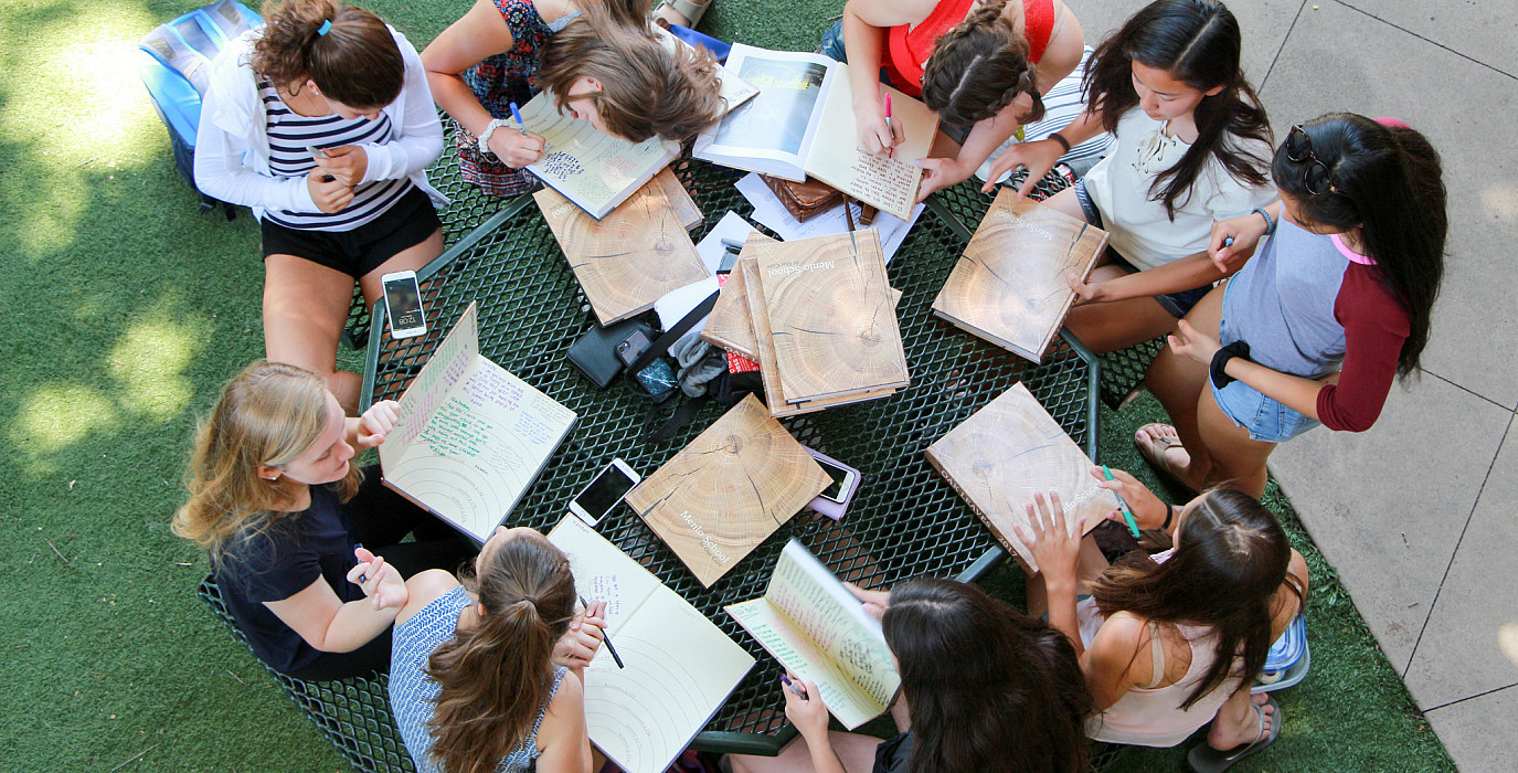 Students gather on the Quad to sign yearbooks during Day on the Green.