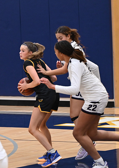 Menlo junior Summer Young pulls down an offensive rebound between Sequoia's Aniyah Hall, front, and Jada Crockett on Friday.