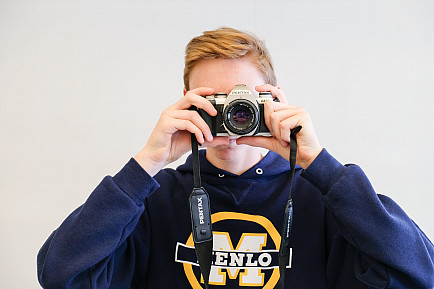 An Upper School photography student poses with their camera.