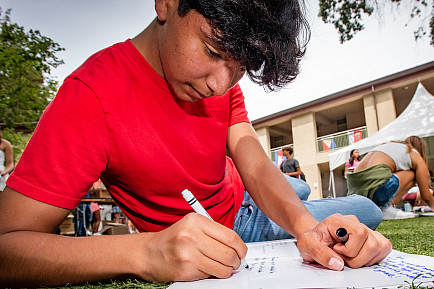 Students gather on the Quad to sign yearbooks during Day on the Green.