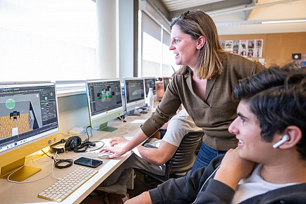 A teacher works with a student in the Animation course.