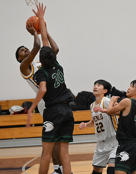 Menlo sophomore Aidan Stull finishes a reverse layup in the second quarter against Harker
