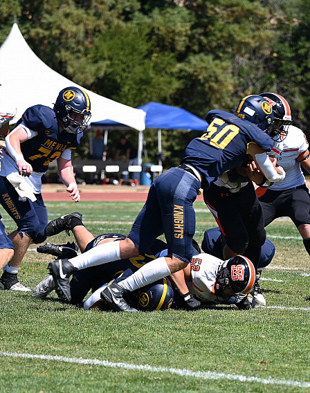 Menlo's Will Farrell (50) stops San Mateo's rusher in the backfield