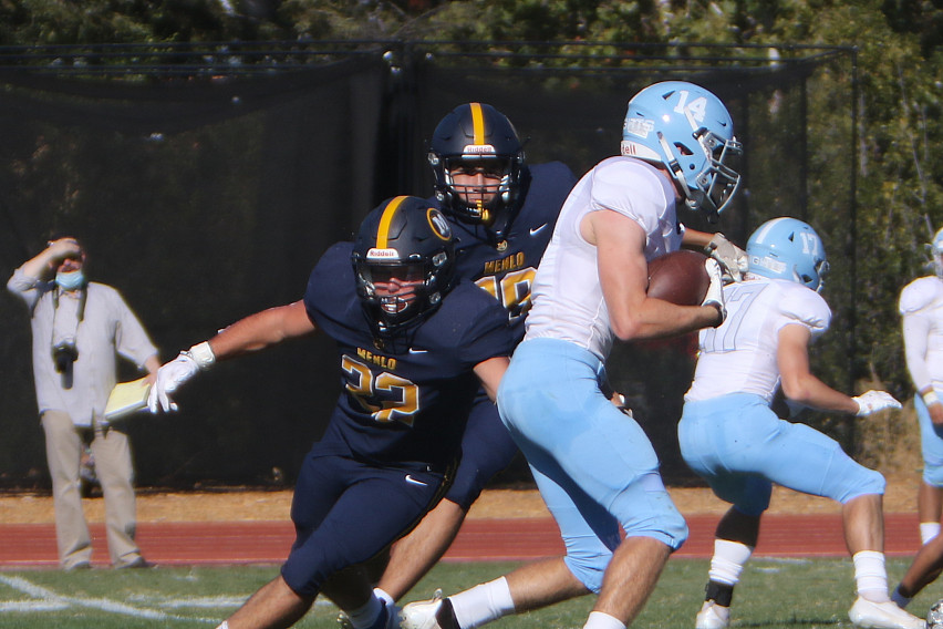 Menlo senior Tyler Flynn moves in to tackle Hillsdale's Zach Leighton in Saturday's game